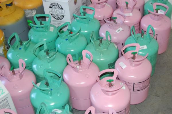 Gallons of R-22 refrigerant sitting on a concrete floor