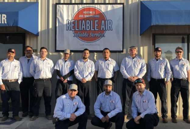 12 Reliable Air techs in branded shirts in front of their office